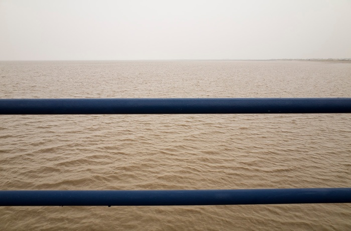 Gentle waves of the Irish Sea through the bars of Southport Pier, England.